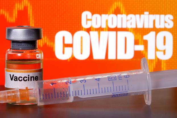 FILE PHOTO: A small bottle labeled with a "Vaccine" sticker stands near a medical syringe in front of displayed "Coronavirus COVID-19" words in this illustration