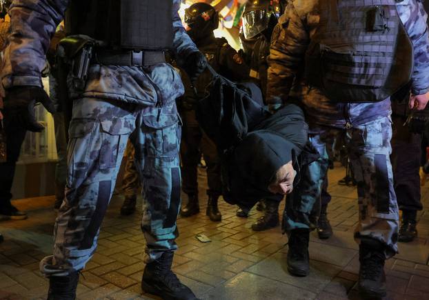 Russian police officers detain a person during an unsanctioned rally in Moscow