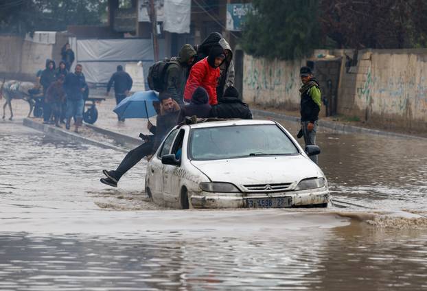 Displaced Palestinians shelter in a tent camp, on a rainy day in Nuseirat