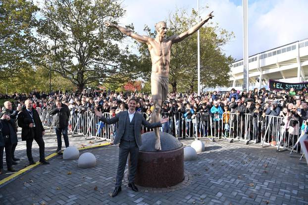 Swedish soccer star Zlatan Ibrahimovic poses in front of a 2,7m bronze statue of him during the unveiling ceremony near Malmo Stadium