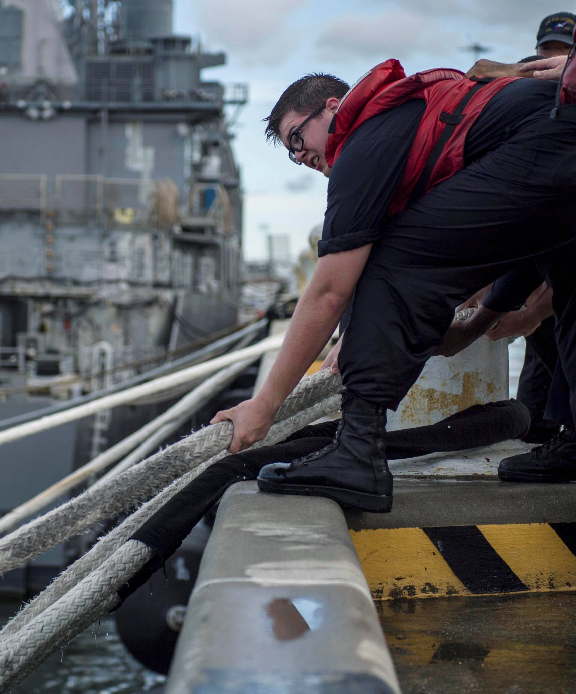 A U.S. Navy handout photo of a sailor heaving line in preparation ahead of Hurricane Florence in Norfolk