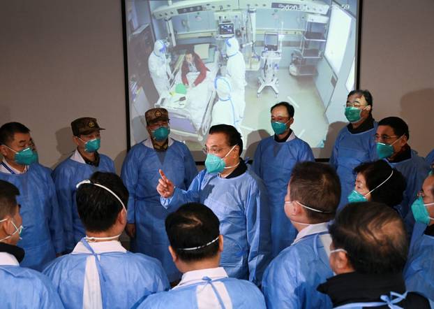 Chinese Premier Li Keqiang wearing a mask and protective suit speaks to medical workers as he visits the Jinyintan hospital where the patients of the new coronavirus are being treated following the outbreak, in Wuhan