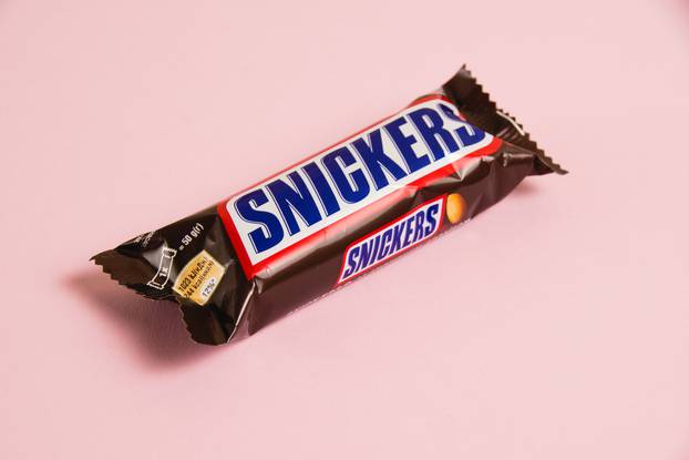Ukraine, Chernihiv, April 26, 2023: Snickers chocolate bar on a pink background