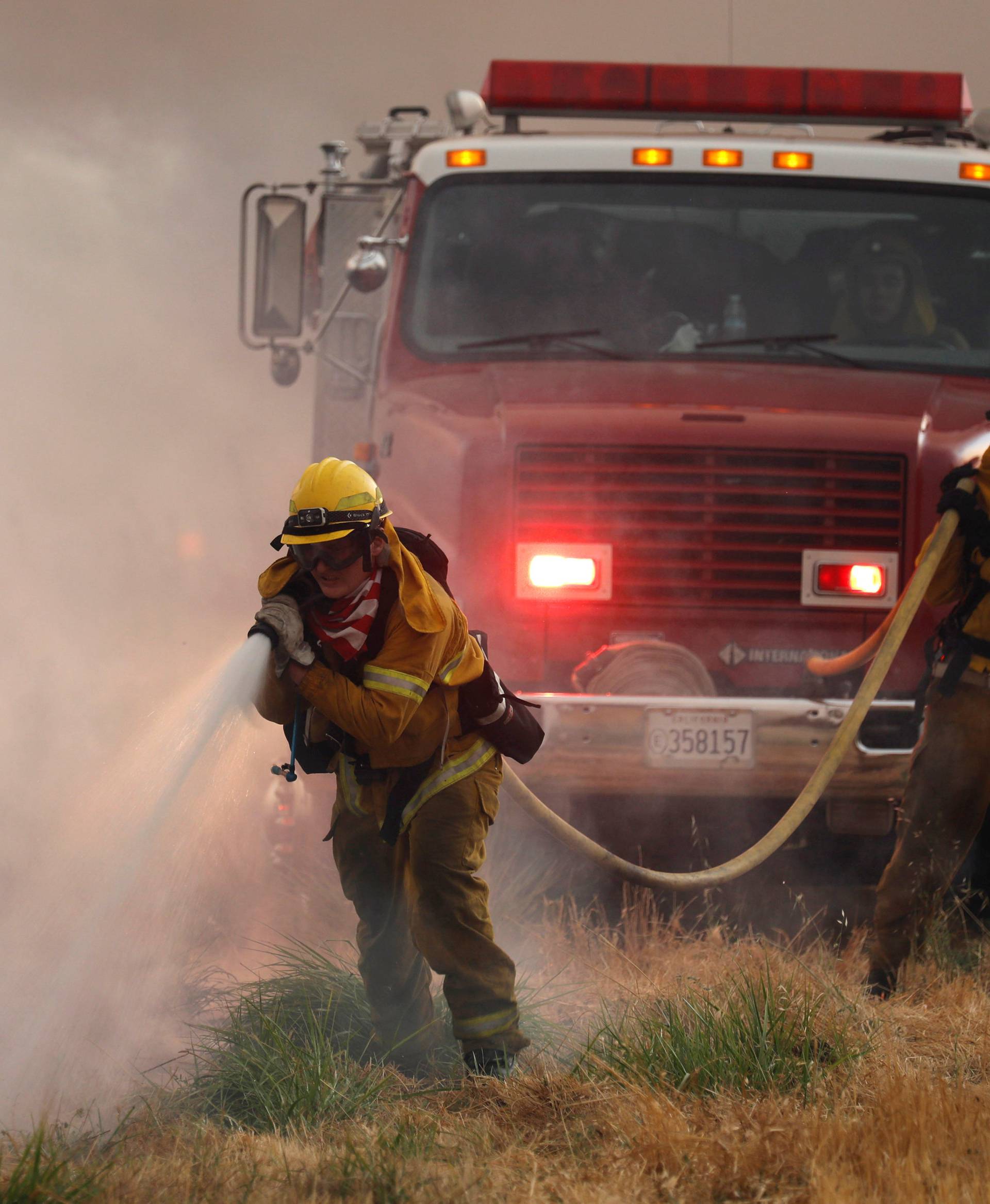 Firefighters knock down hotspots to slow the spread of the River Fire in Lakeport