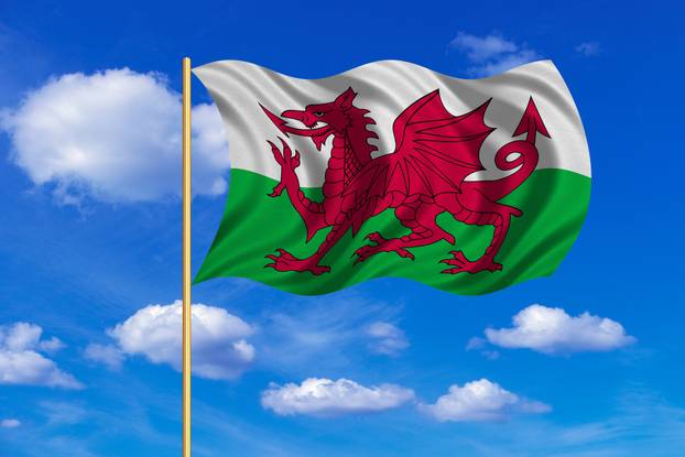 Flag of Wales waving on blue sky background