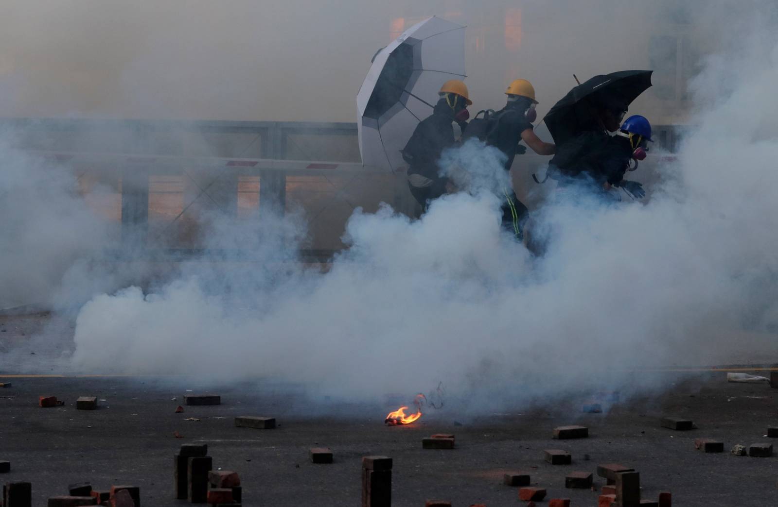 Protesters run after they are tear gassed by police at the Hong Kong Polytechnic University (PolyU)