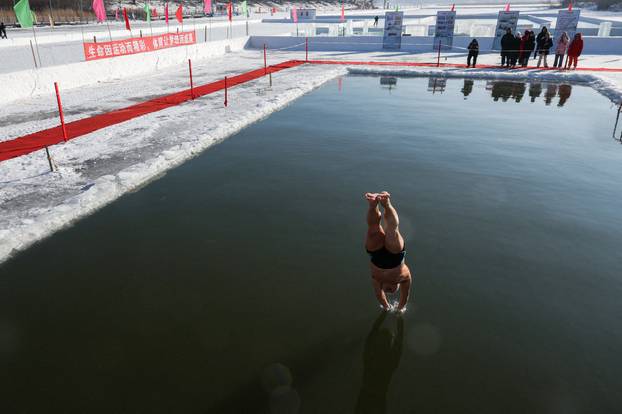 Locals participate in winter swimming events during annual ice and snow sculpture festival, in Harbin