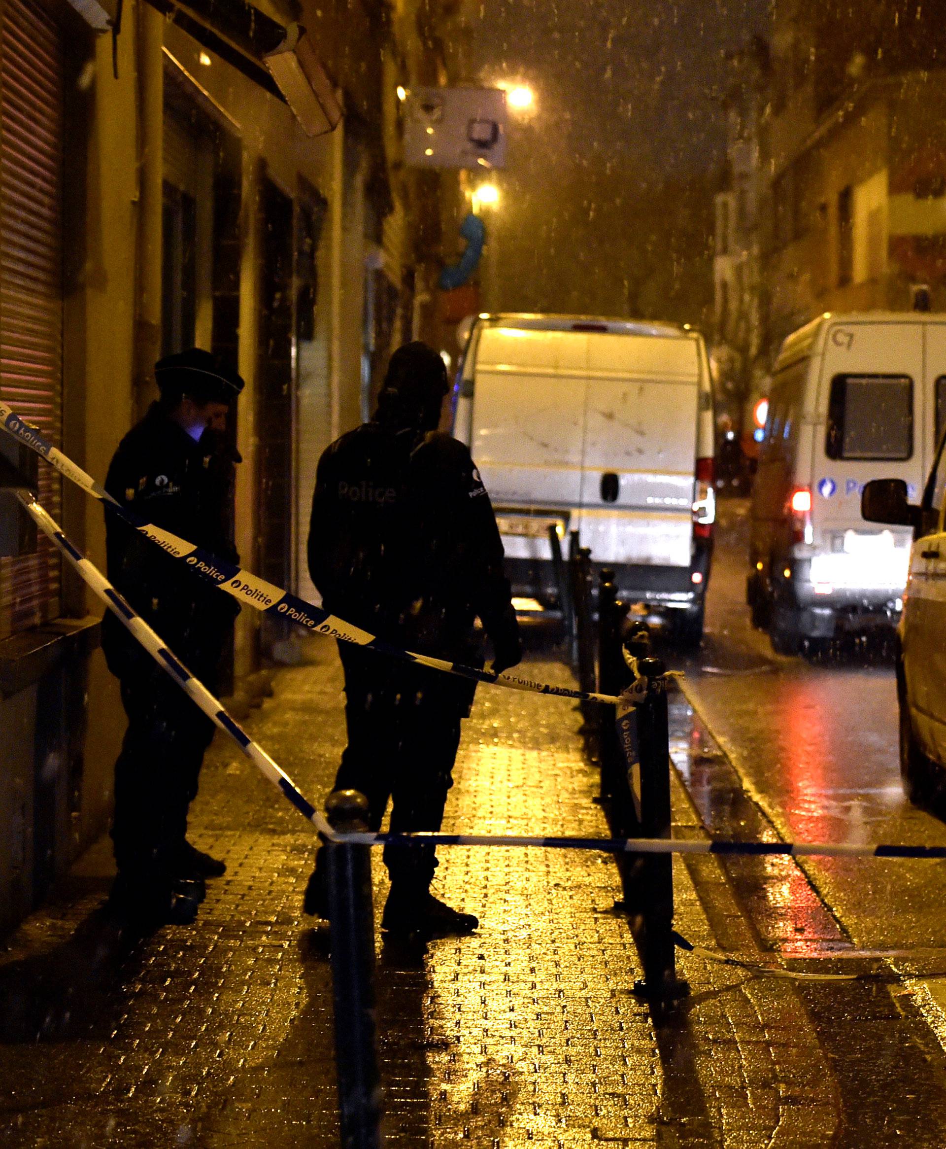 Belgian police officers stand guard at the scene of a security operation in the Brussels district of Molenbeek