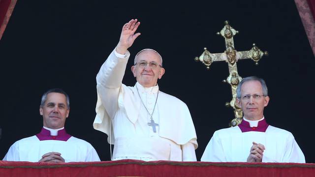 Pope Francis waves as he leads the "Urbi et Orbi" (to the city and the world) message from the balcony overlooking St. Peter's Square at the Vatican