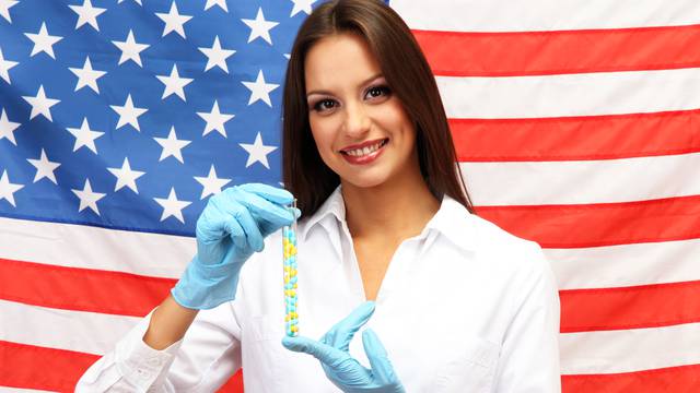Portrait of female doctor or scientist showing and analyzing pills over American Flag background
