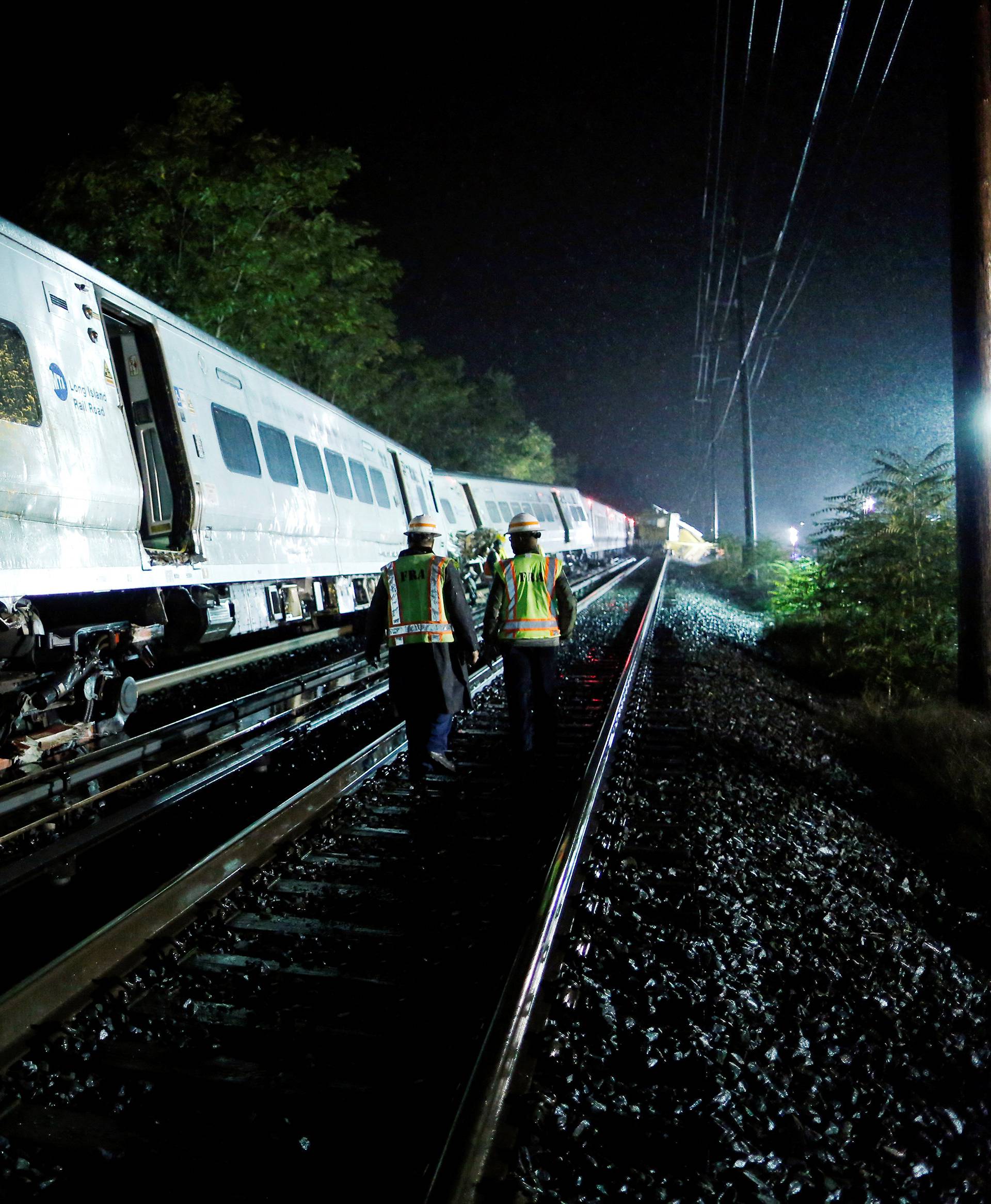 Emergency responders work near a train that sits derailed near the community of New Hyde Park on Long Island in New York