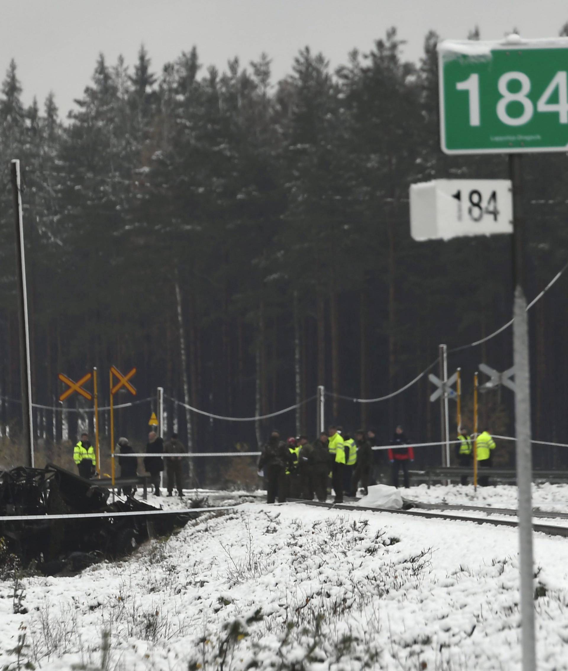 Rescue and military personnel are seen at the railroad crossing after a crash between a train and a military truck in Raasepori