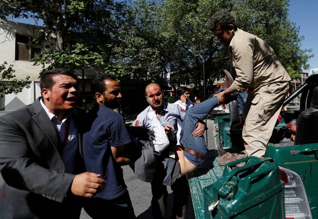 Men move an injured man to a hospital after a blast in Kabul, Afghanistan