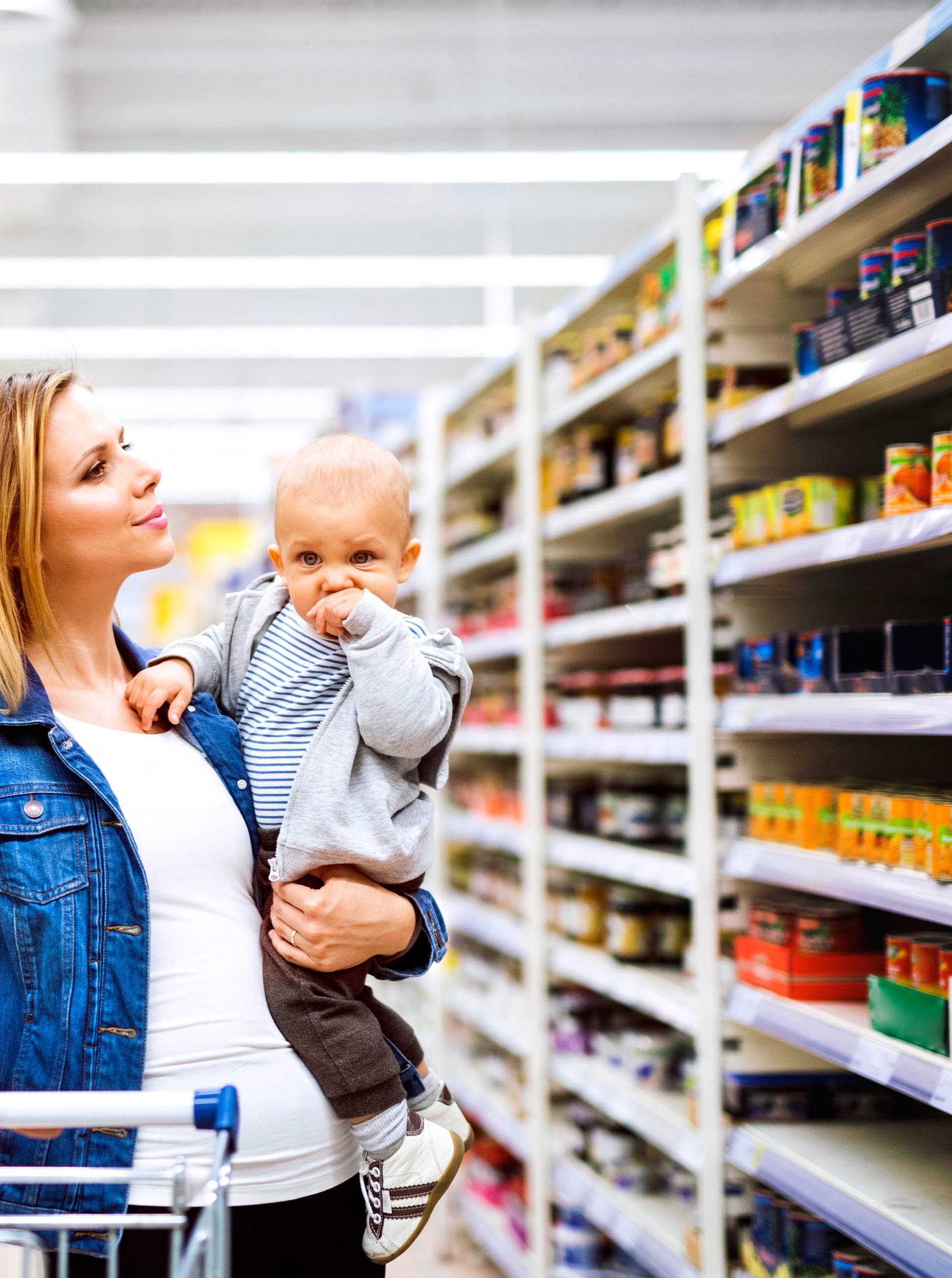 Young mother with her little baby boy at the supermarket.