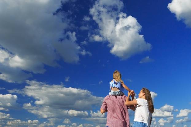 Mom dad and daughter look at the sun in the wheat field. Back vi