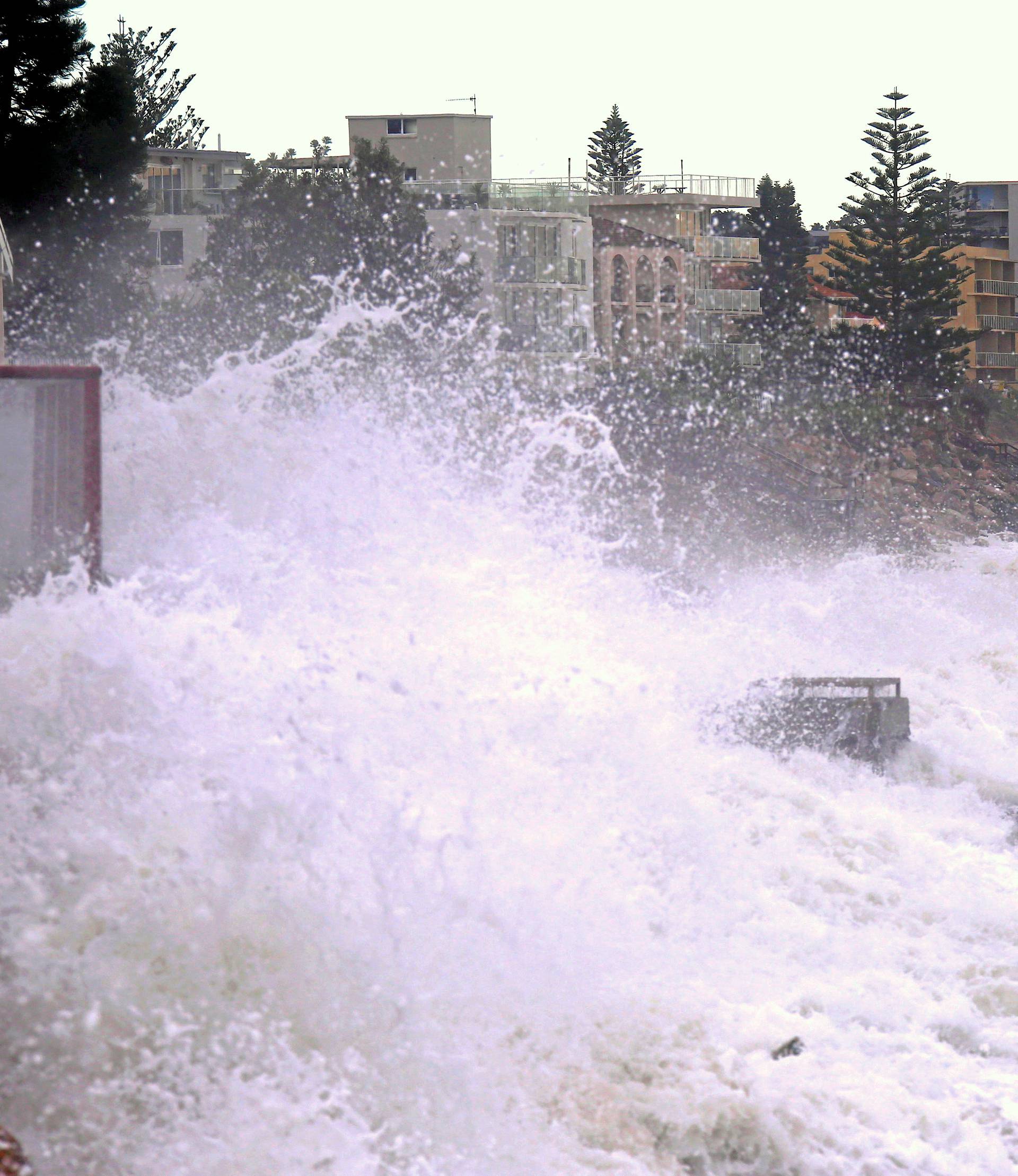 A large wave splashes onto properties located on Collaroy Beach that were damaged due to severe weather that brought strong winds and heavy rain to the east coast of Australia in Sydney