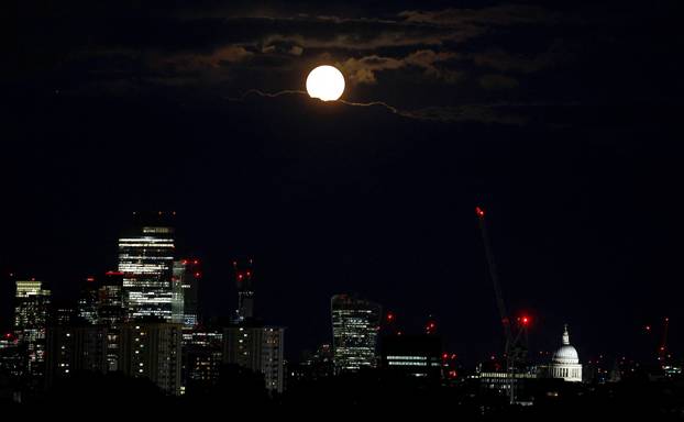 A super-moon, know as the Blue Moon, appears from behind clouds over London