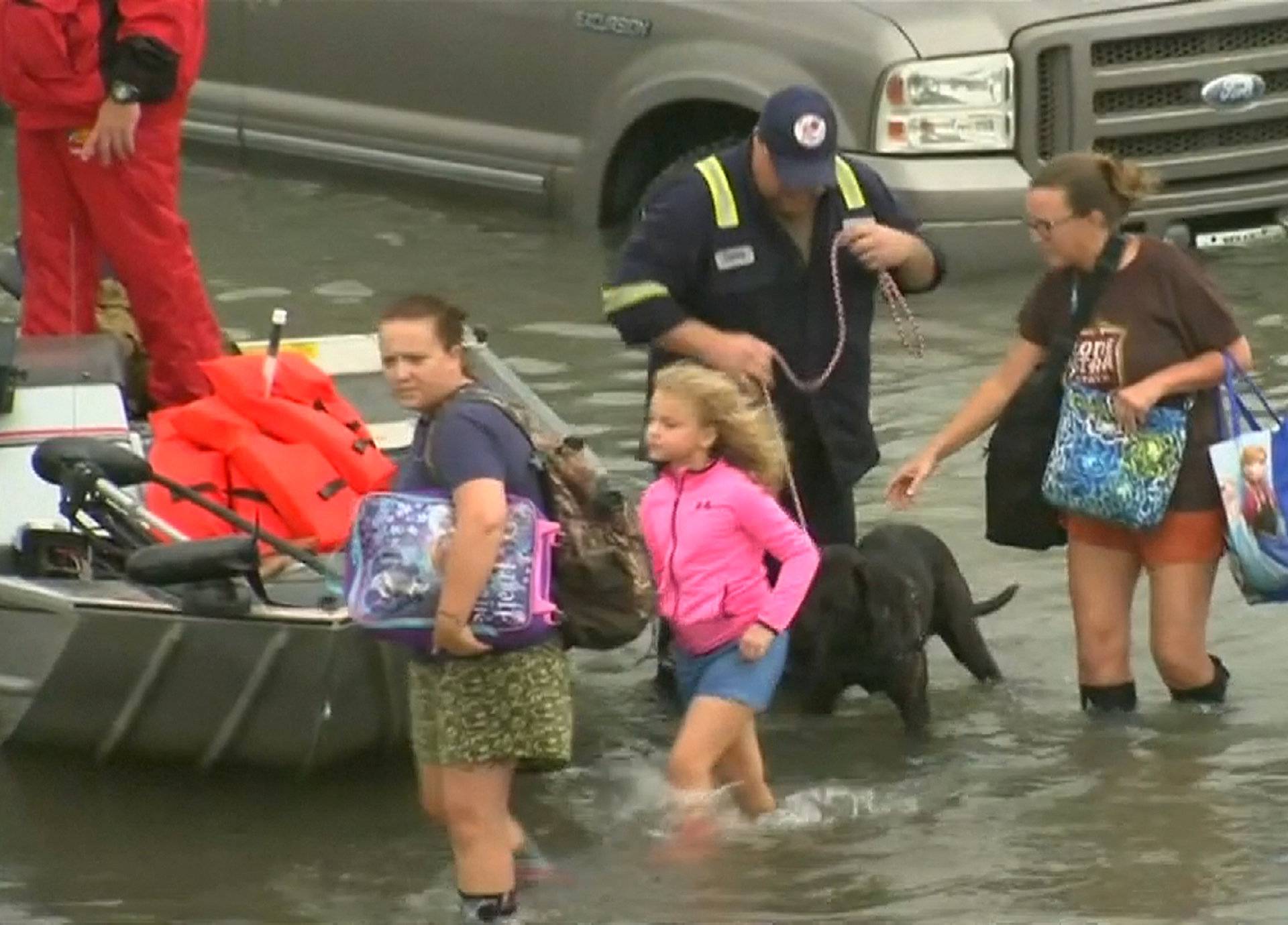 Evacuees exit a rescue boat in the flood waters of Tropical Storm Harvey in Port Arthur