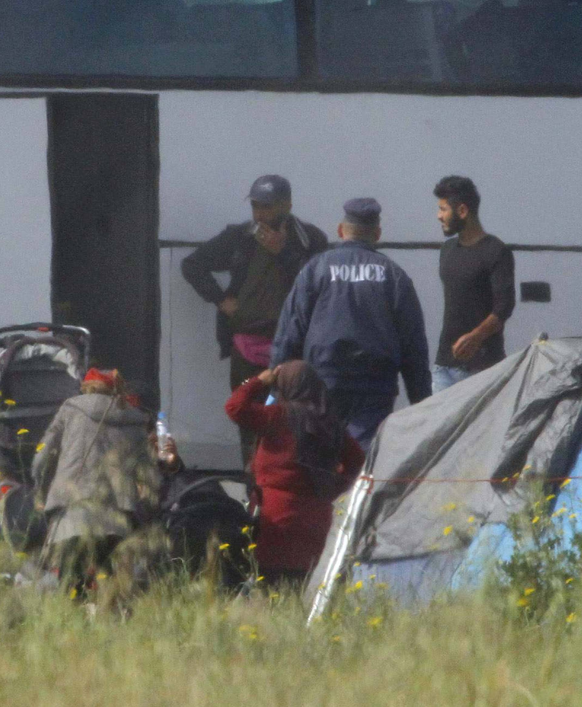 Refugees and migrants are transferred by buses during police operation to evacuate makeshift camp nearIdomeni