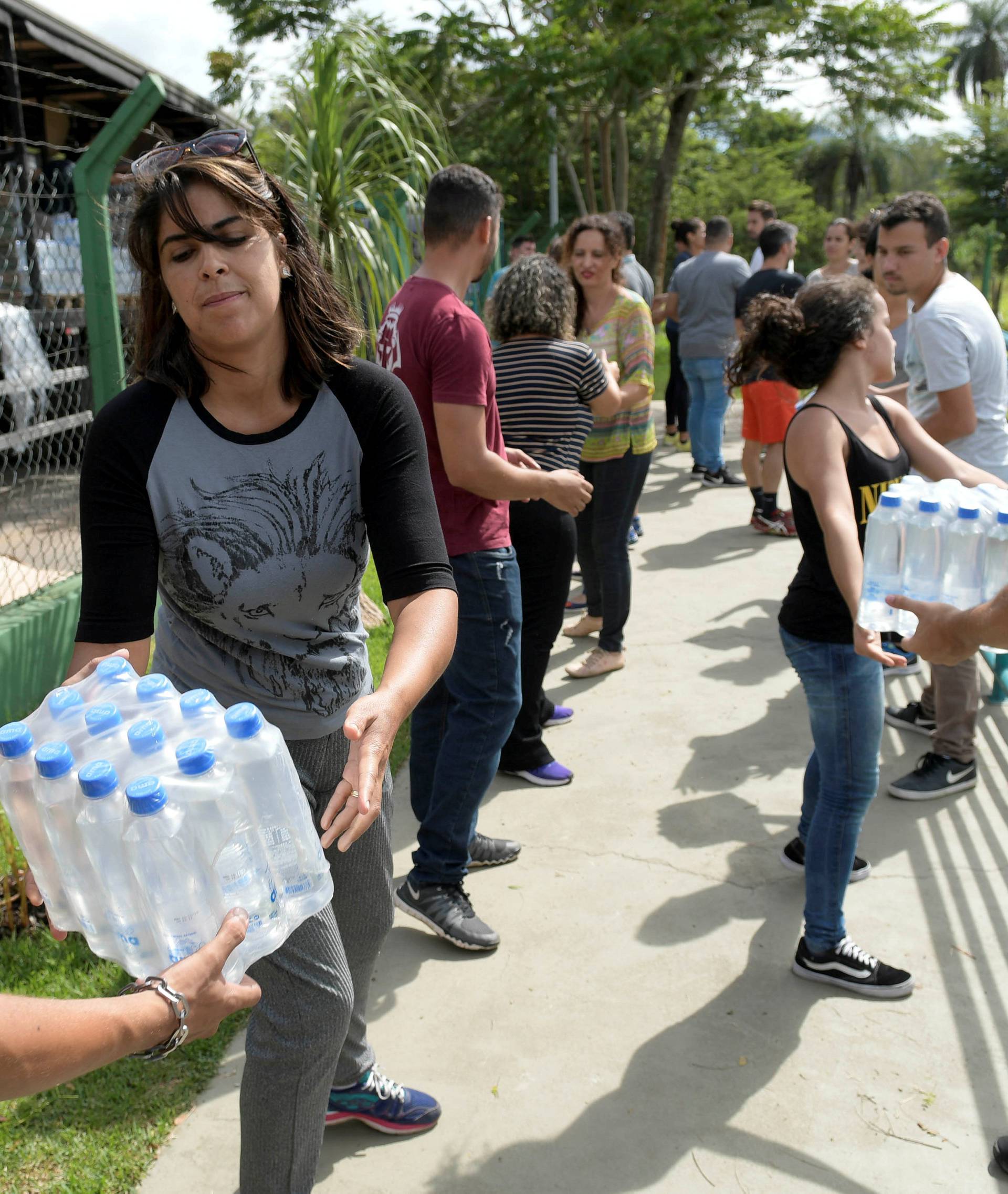 Volunteers pass bottles of water for people affected by a failed iron ore tailings dam owned by Brazilian miner Vale SA that burst, in Brumadinho