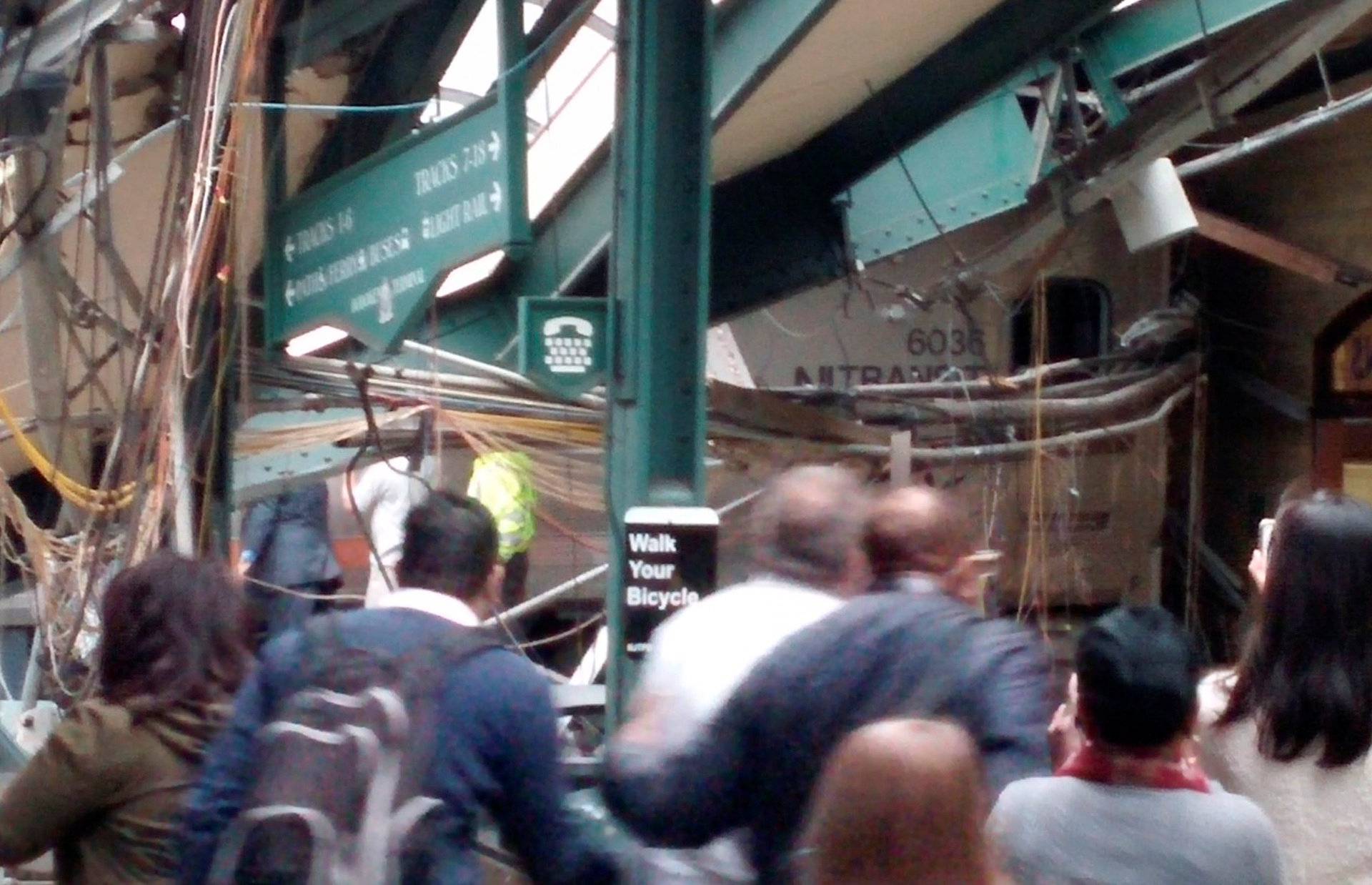 Onlookers view a New Jersey Transit train that derailed and crashed through the station in Hoboken, New Jersey, 
