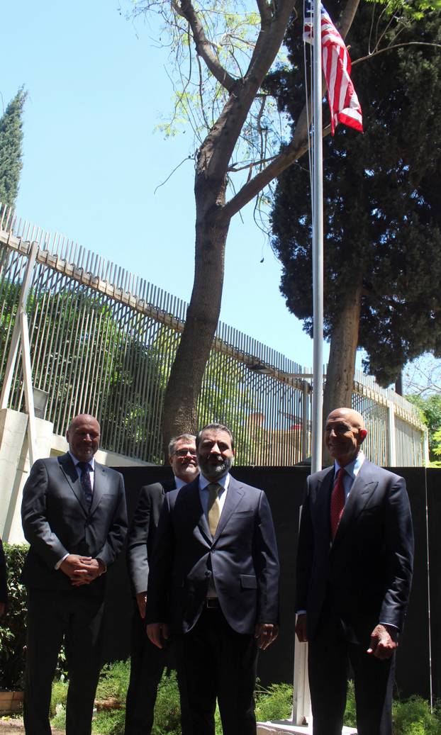 Syrian Foreign Minister Asaad Hassan al-Shibani stands next to U.S. envoy for Syria Thomas Barrack after he raised the American flag at U.S. ambassador's residency in Damascus