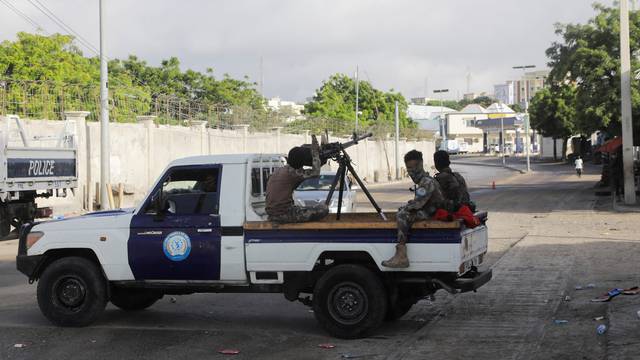 Somali policemen sit on a pickup truck as they enforce a curfew on the day of the Somali presidential elections, in Mogadishu