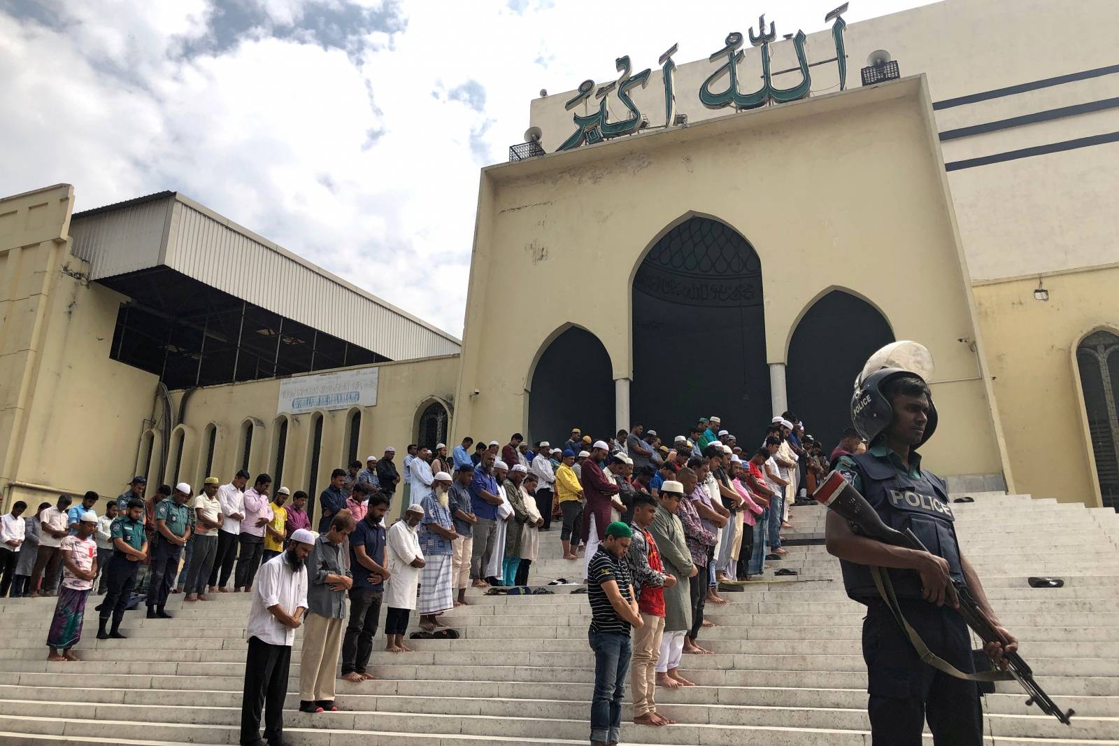 A police officer stands gurad during Friday prayers at the Baitul Mukarram National Mosque, providing extra security after the Christchurch mosque attacks in New Zealand, in Dhaka