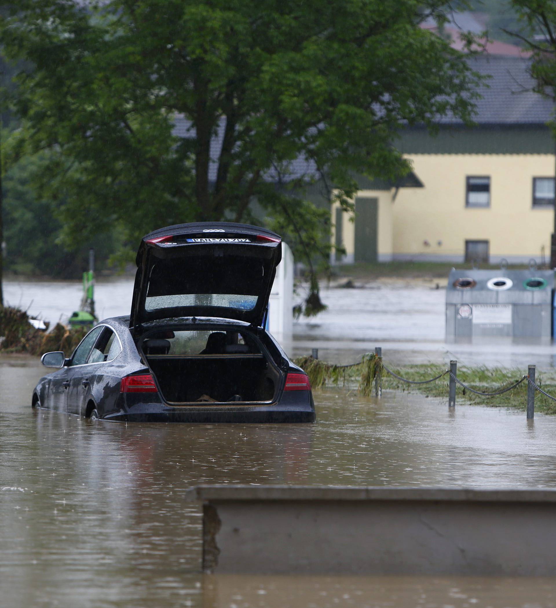 A car stands in the water in the flooded street in the Bavarian village of Triftern