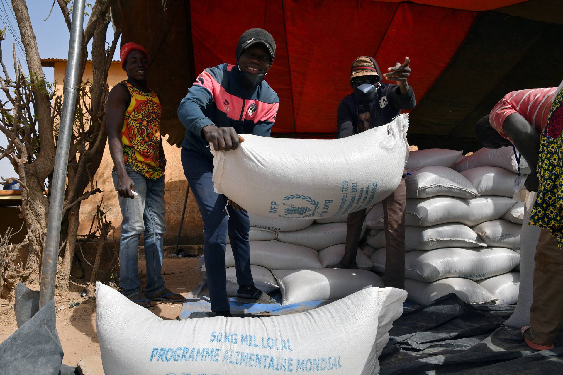 FILE PHOTO: Workers carry the aid provided by the World Food Programme (WFP) for distribution in Pissila