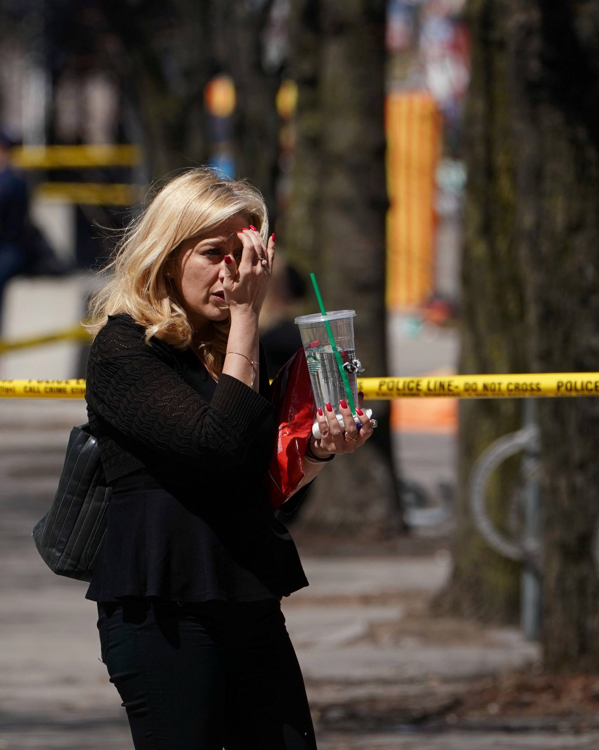 A pedestrian walks along a police crime scene tape near where a van struck multiple people at a major intersection in Toronto's northern suburbs in Toronto