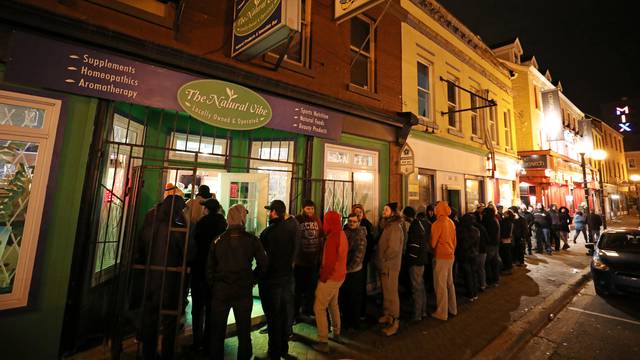 Customers line up outside the Natural Vibe store after legal recreational marijuana went on sale in St John's