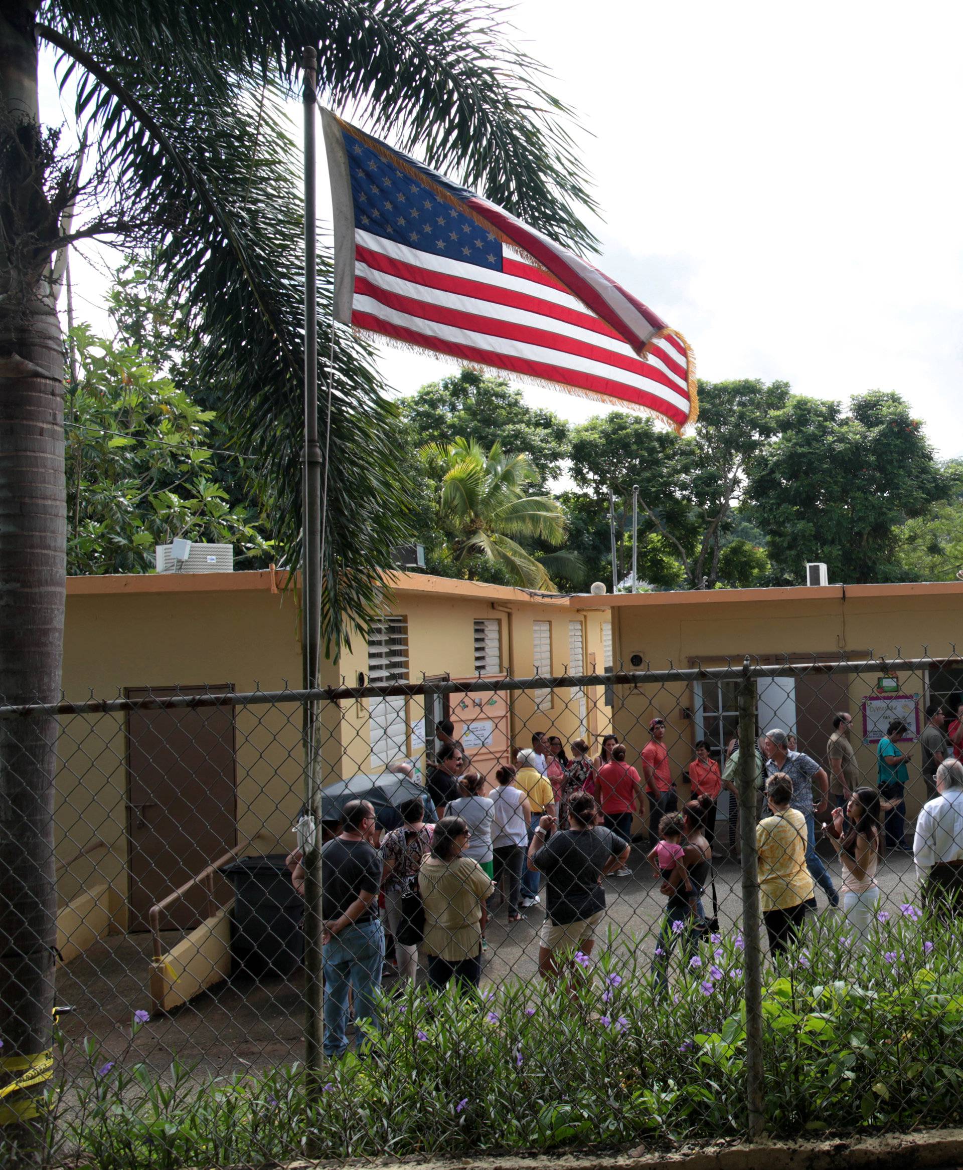 People stand outside a school turned into a polling station to cast their vote in the country's gubernatorial elections, in Guaynabo