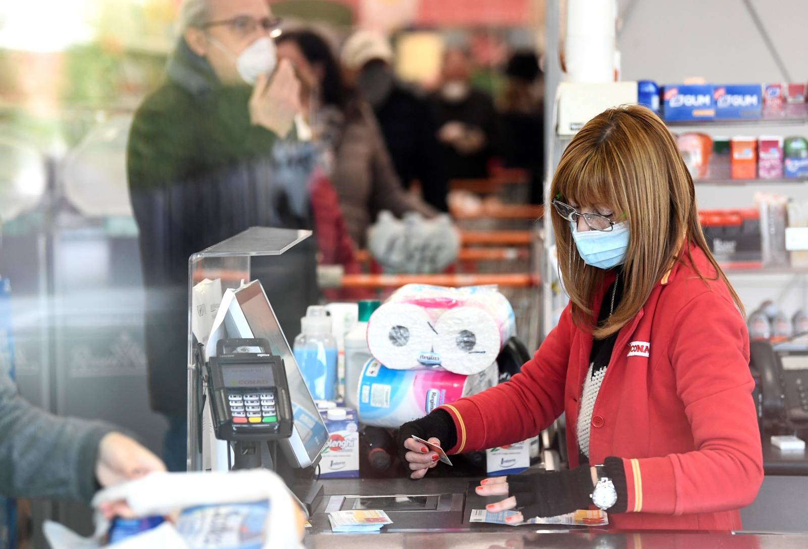 A worker wearing a face mask is pictured at a supermarket in the town of Casalpusterlengo