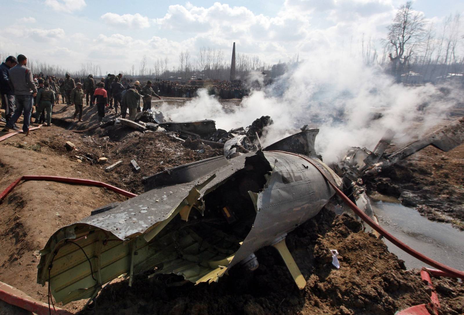 People stand next to the wreckage of Indian Air Force's helicopter after it crashed in Budgam district