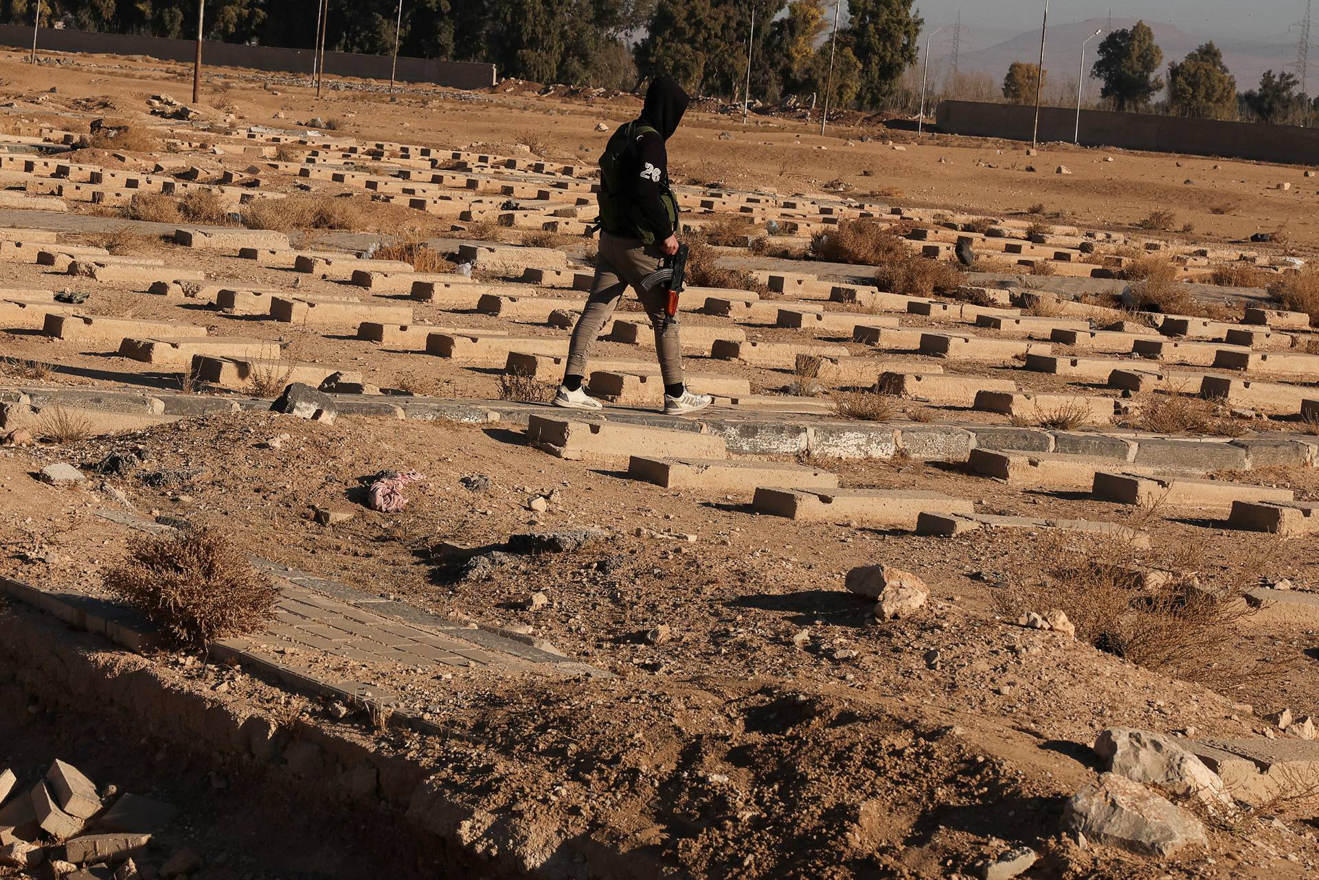 People inspect the site of a mass grave from under the rule of Syria's Bashar al-Assad, in Najha