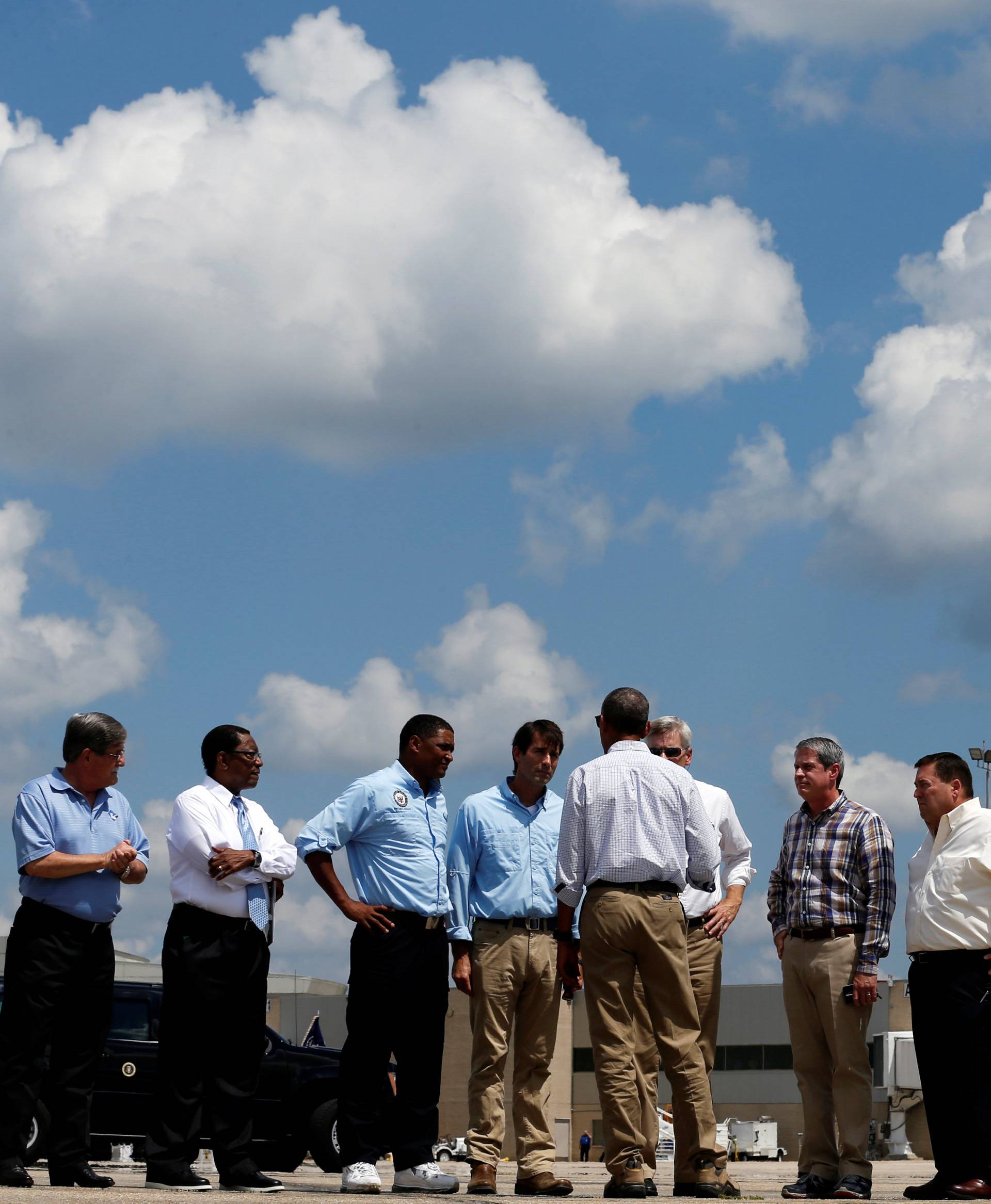 U.S. President Barack Obama speaks with local and state officials as he arrives aboard Air Force One at Baton Rouge Metropolitan Airport in Baton Rouge