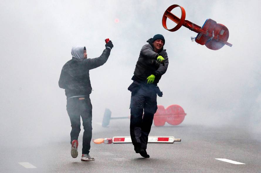 Far-right supporter throws a traffic sign during a protest against Marrakesh Migration Pact in Brussels