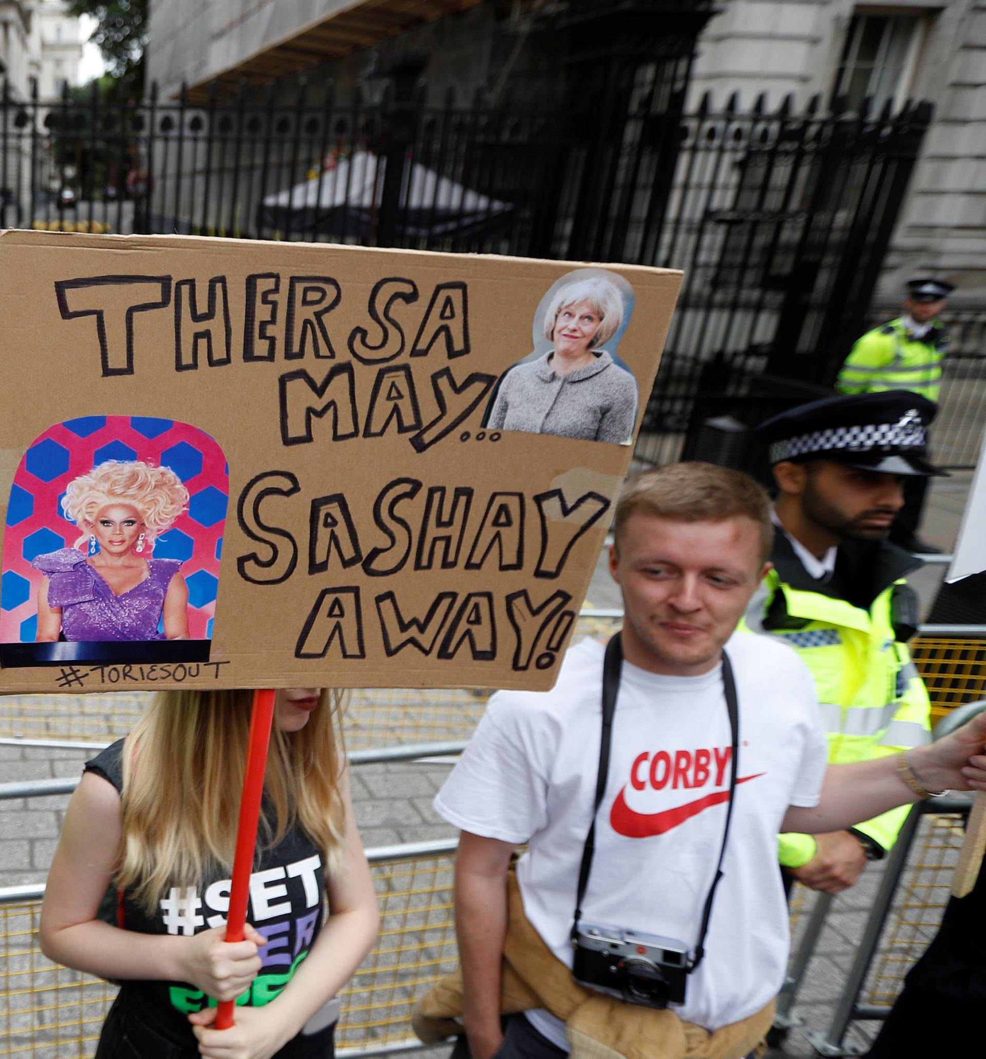 Demonstrators stand at the end of Downing Street during an anti-austerity rally and march organised by campaigners Peoples' Assembly, in central London