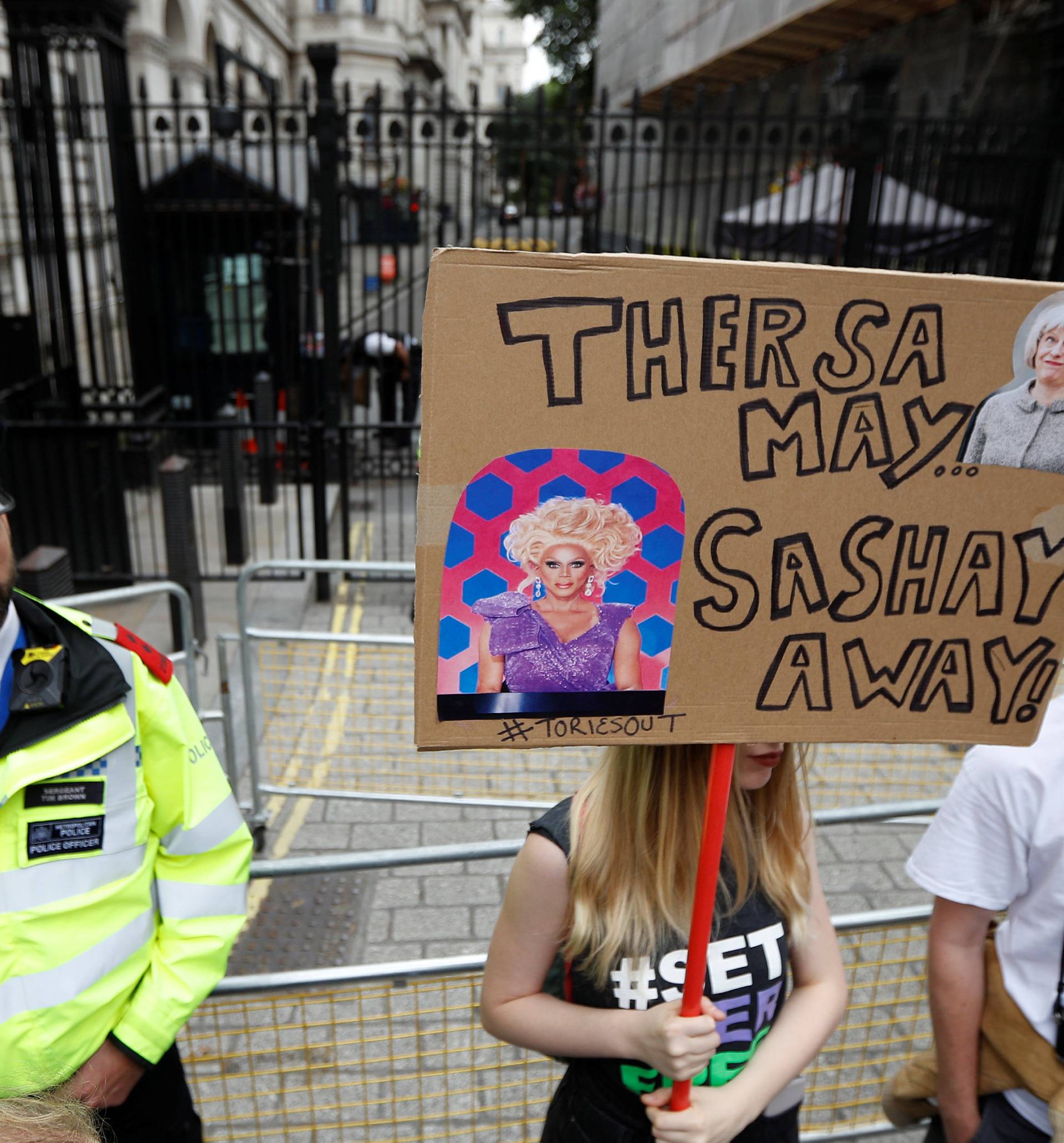 Demonstrators stand at the end of Downing Street during an anti-austerity rally and march organised by campaigners Peoples' Assembly, in central London