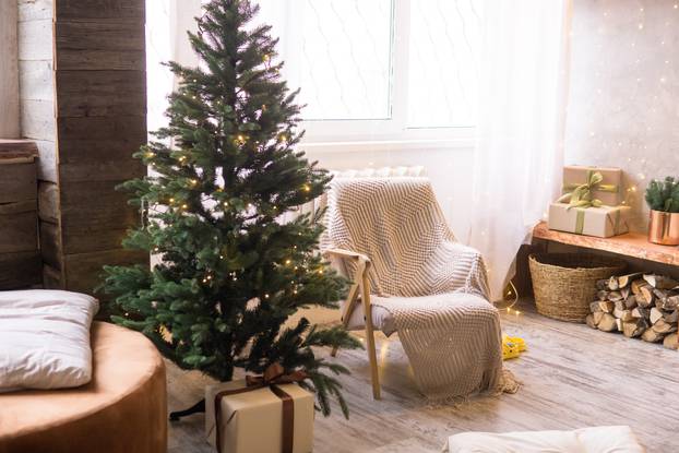 Home New Year's interior. Christmas tree with gifts, decorated with garlands. Cozy atmosphere of a home holiday, loft design of the room, Scandinavian style