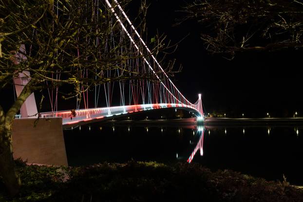 Osijek: Pješački most osvijetljen crveno bijelom  bojom povodom Dana sjećanja na žrtvu Vukovara i Škabrnje