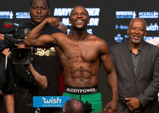 Undefeated boxer Floyd Mayweather Jr. of the U.S. poses in the scale during his official weigh-in at T-Mobile Arena in Las Vegas