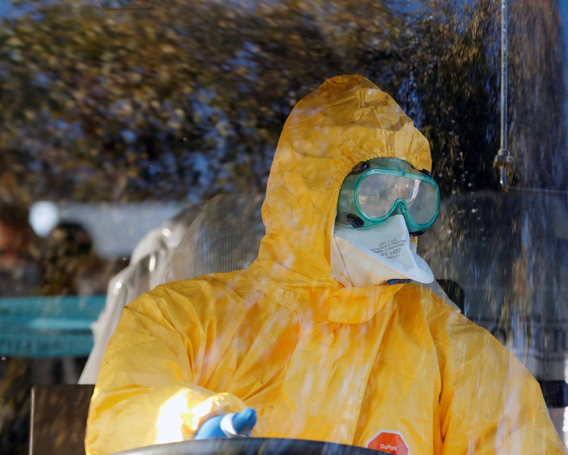 A driver wearing a protective suit carries European passengers who were evacuated from the coronavirus-stricken Diamond Princess cruise ship in Japan, as they leave the Pratica di Mare military airport in Rome