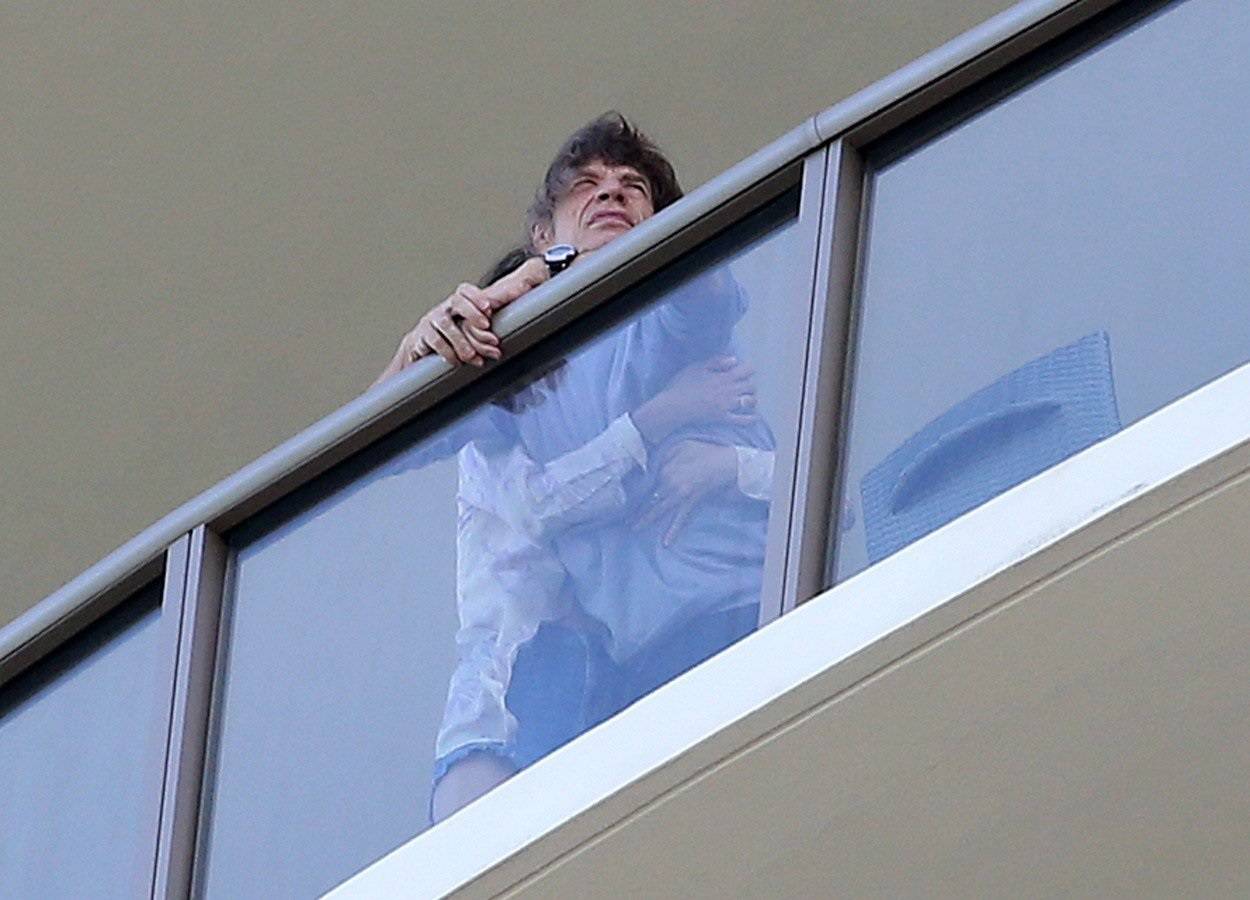 EXCLUSIVE: Mick Jagger is seen playing with his son and being comforted by his wife  Melanie Hamrick on their balcony in Miami