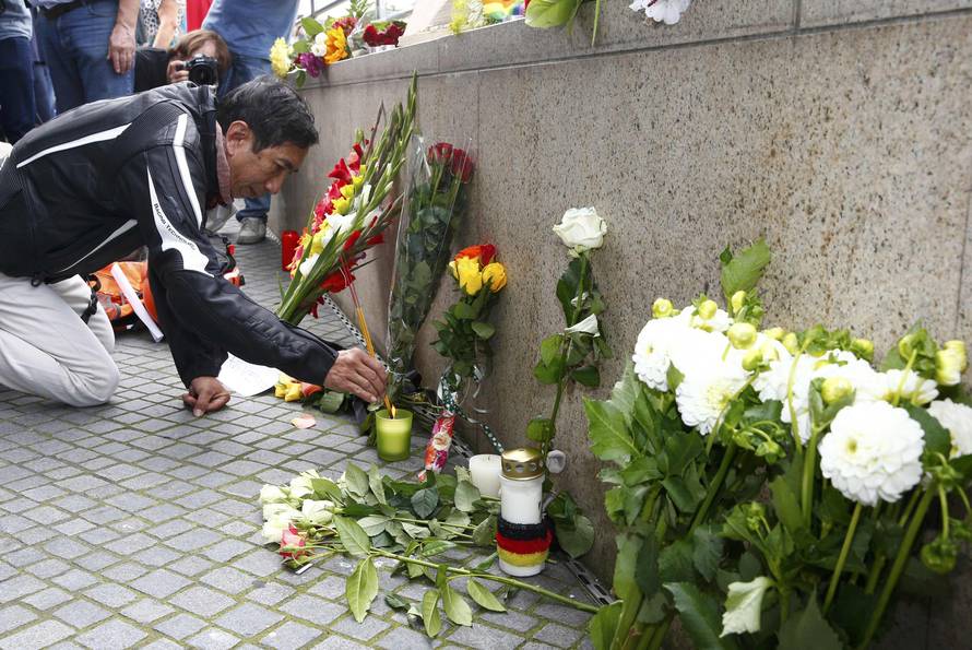 A man lights incense sticks near Olympia shopping mall in Munich