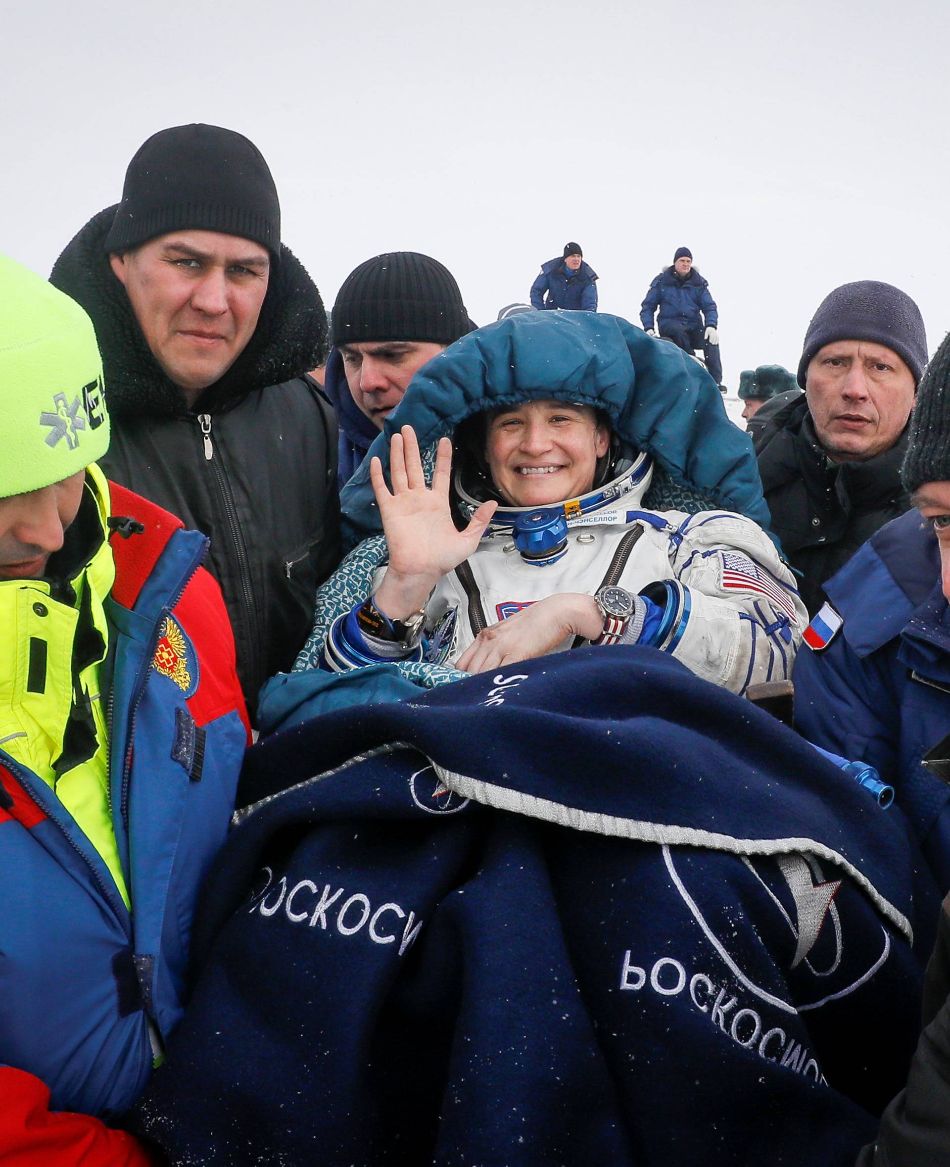 Ground personnel carry International Space Station crew member Aunon-Chancellor after landing near Zhezkazgan