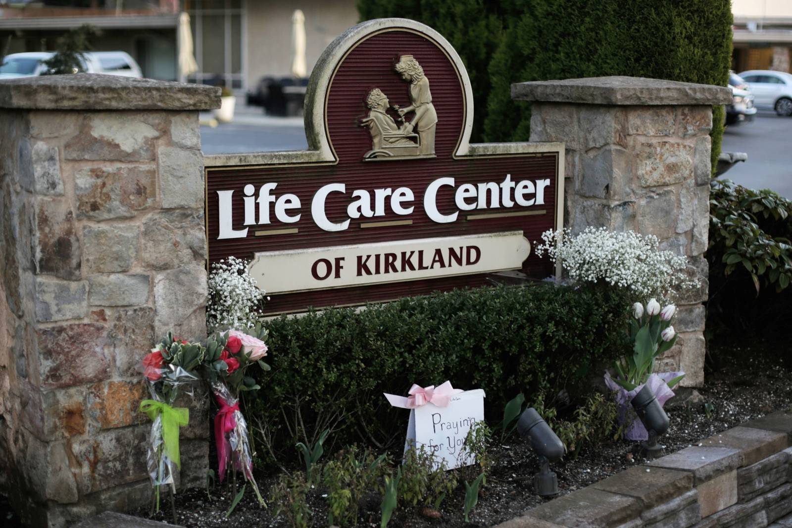 A homemade sign and flowers from community members are seen near the entrance to the Life Care Center of Kirkland