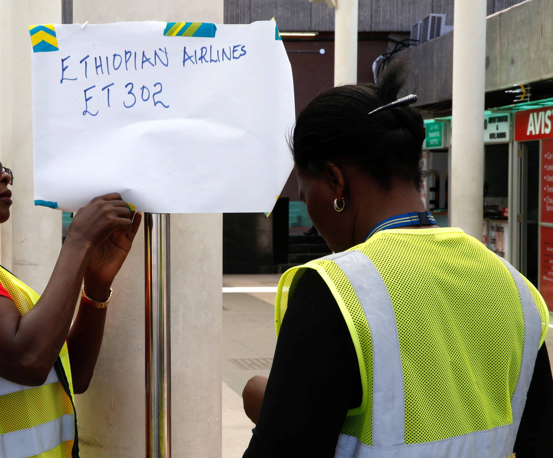 Kenya Airports Authority (KAA) workers hang an information notice of Ethiopian Airlines Flight ET 302, at the Jomo Kenyatta International Airport in Nairobi