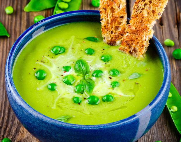Green pea soup on wooden rustic background
